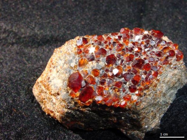 Gemmy reddish-orange crystals on a light gray rock matrix.