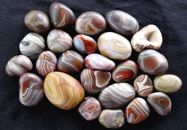 Smooth, round pebbles with bands of red, brown, gray, orange, yellow, and white.