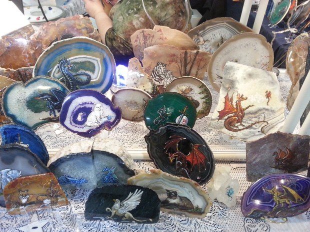 Colorful agate slabs with dragons, cats, penguins, and other creatures painted on them.