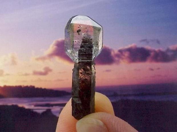 A small stock of smoky quartz intersecting a transparent spherical piece of quartz.
