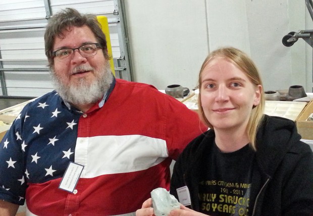 People posing with an aquamarine crystal